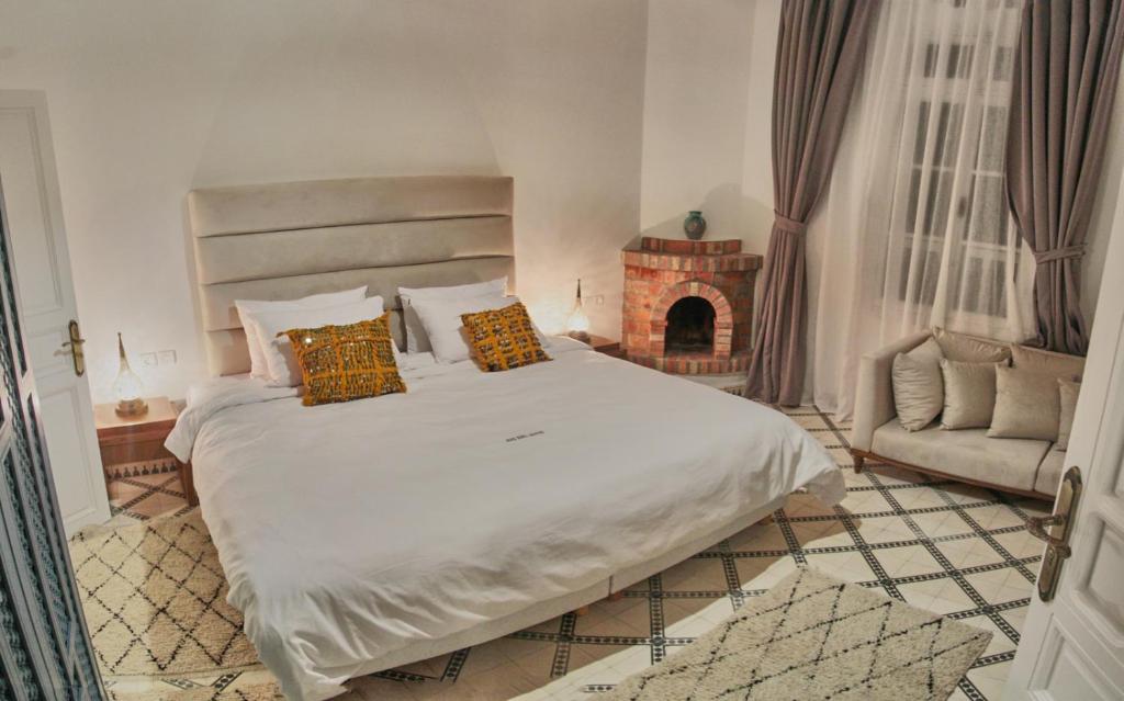 - une chambre avec un grand lit et une cheminée dans l'établissement Riad Borj El Baroud, à Essaouira