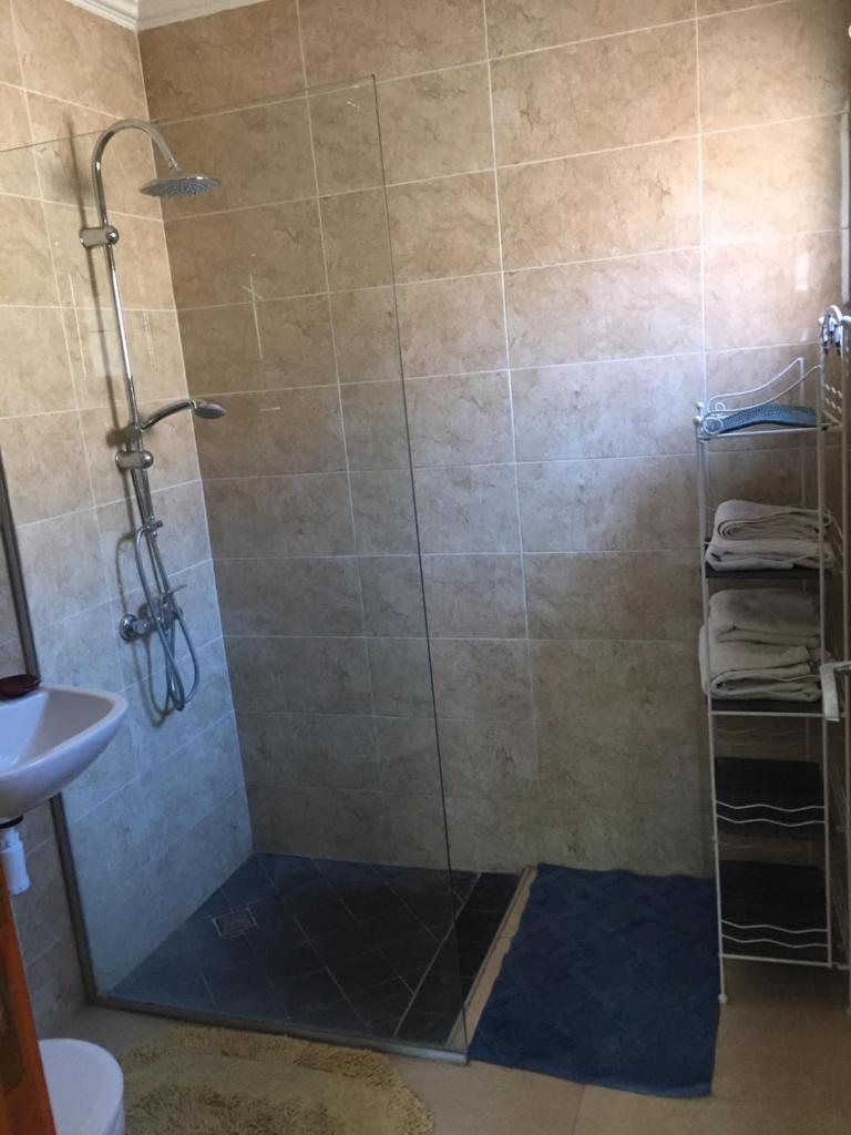 une douche avec une porte vitrée dans une salle de bain dans l'établissement Riad Lalla Zahra, à Marrakech