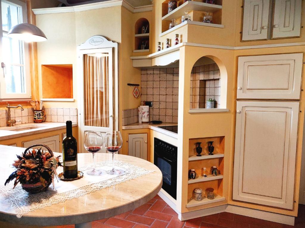 une cuisine avec une table et deux verres de vin dans l'établissement Tuscan Villa exclusive use of private pool A/C Wifi Villa Briciola, à Capannori