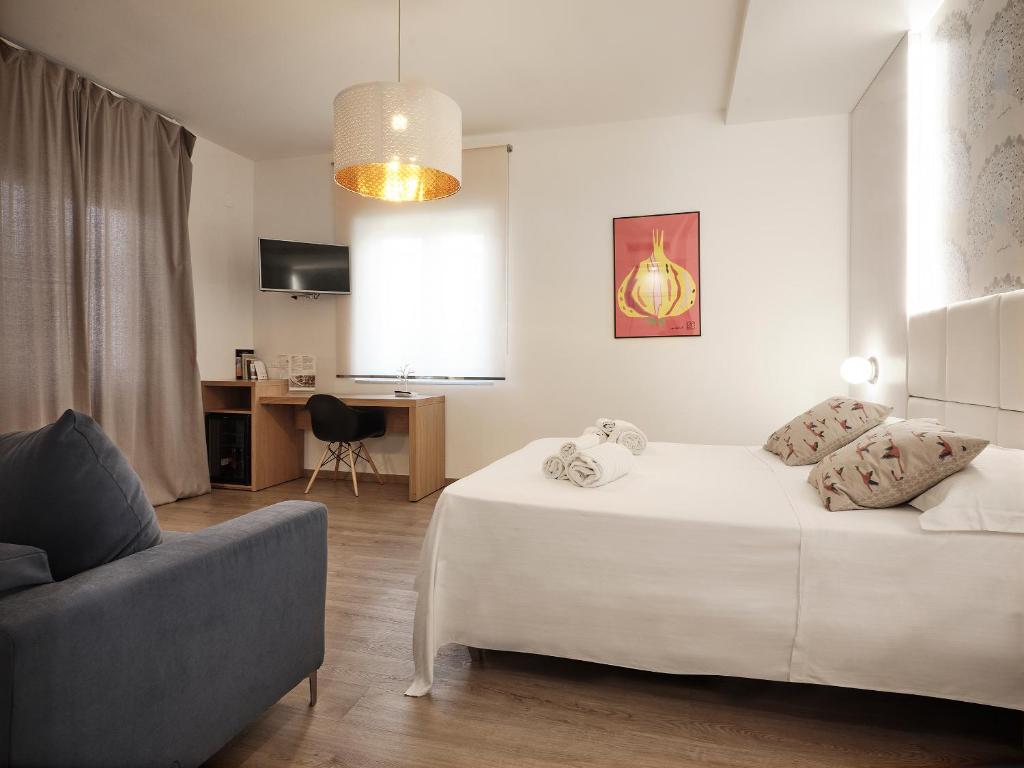 - un salon avec un lit blanc et un canapé dans l'établissement Hotel Royal Paestum, à Paestum