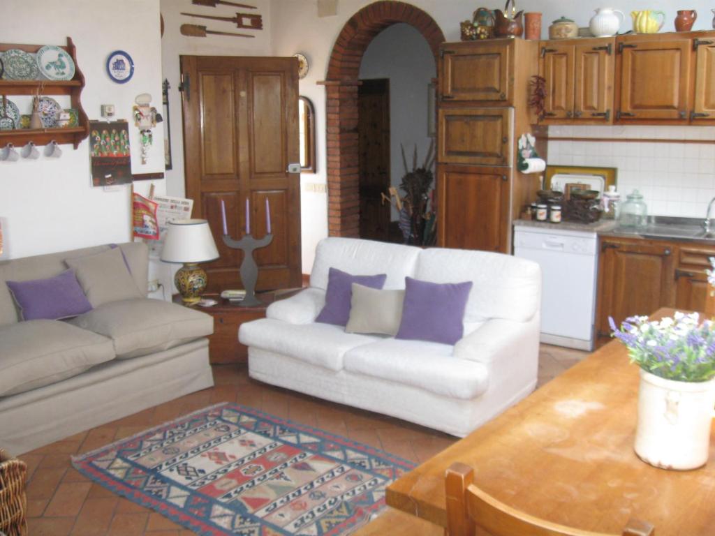 - un salon avec un canapé blanc et des oreillers violets dans l'établissement Casale Le Borghe - Montalcino,Toscana, à San Giovanni dʼAsso