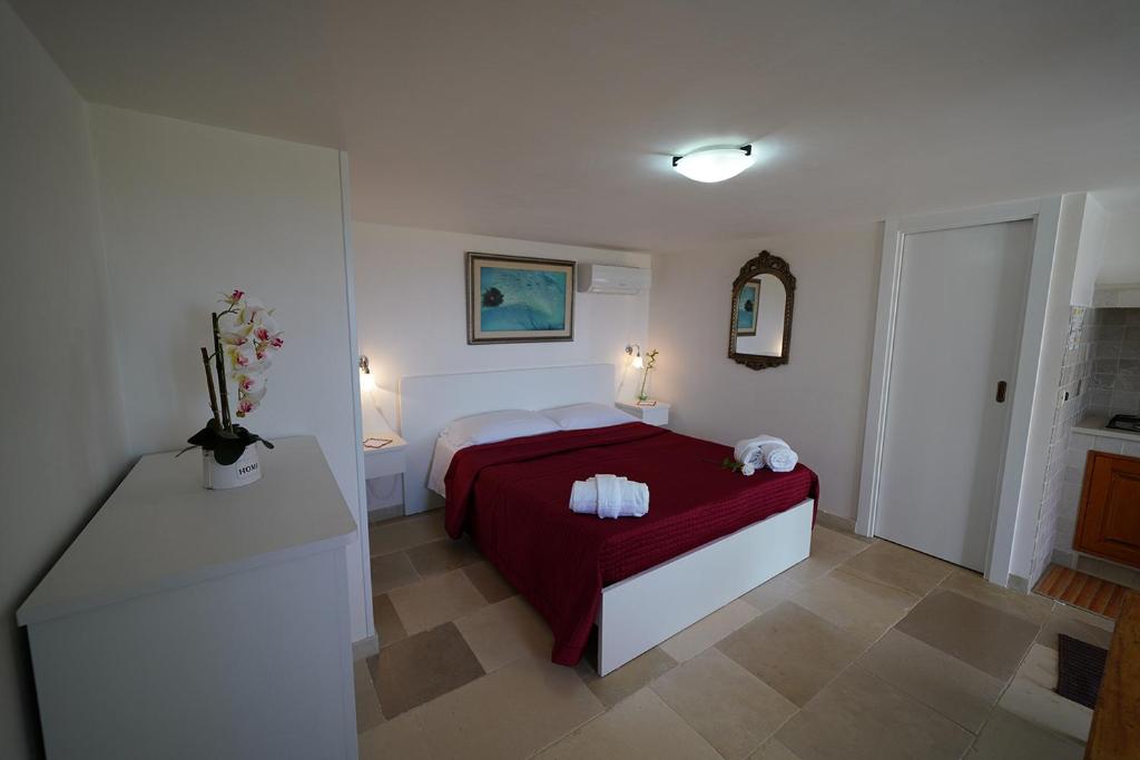 une chambre avec un lit avec une couverture rouge dans l'établissement Villa Belvedere, à Ostuni
