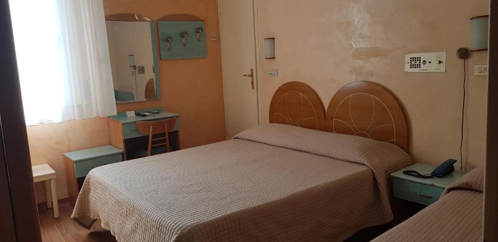 - une petite chambre avec 2 lits et un miroir dans l'établissement Hotel Britannia Rimini Marina centro, à Rimini