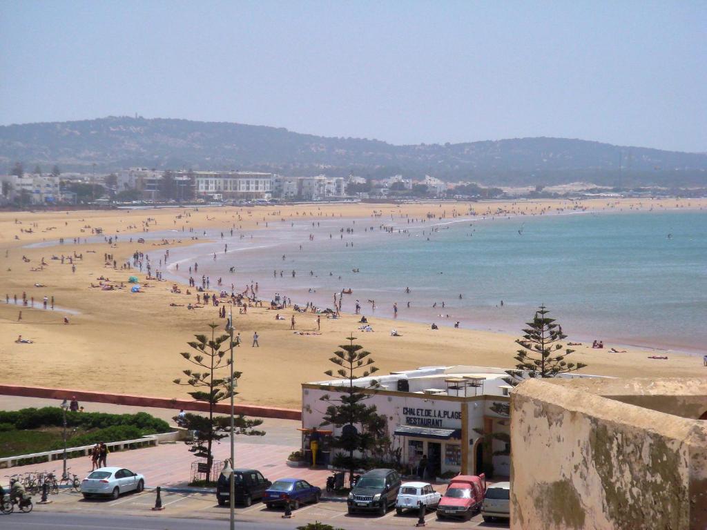 un groupe de personnes sur une plage avec l'océan dans l'établissement Riad Borj El Baroud, à Essaouira