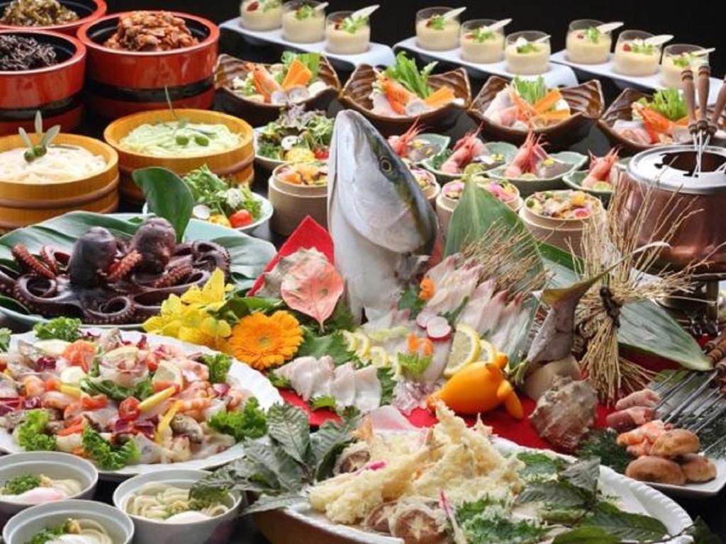 une table avec de nombreux plats différents dans l'établissement Bay Resort Hotel Shodoshima, à Shodoshima