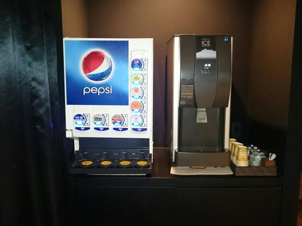une machine à Pepsi posée sur un comptoir dans l'établissement Hotel Crest Hirai (Adult Only), à Tokyo