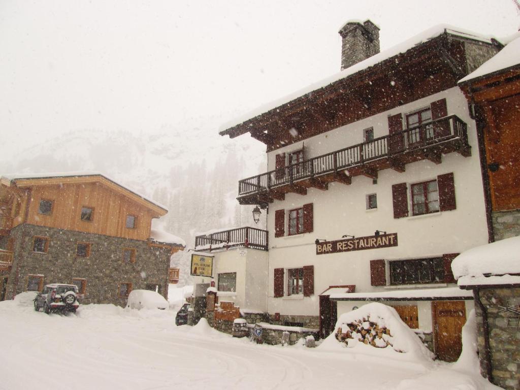une tempête de neige dans les montagnes avec un bâtiment dans l'établissement Le Dôme, à Tignes