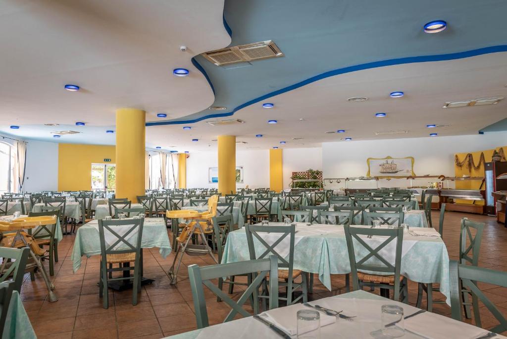 une salle à manger avec des tables et des chaises et un plafond bleu dans l'établissement Nicotera Beach Village, à Nicotera Marina