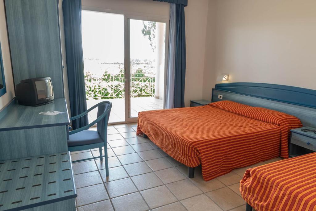 une chambre d'hôtel avec deux lits et une télévision dans l'établissement Nicotera Beach Village, à Nicotera Marina