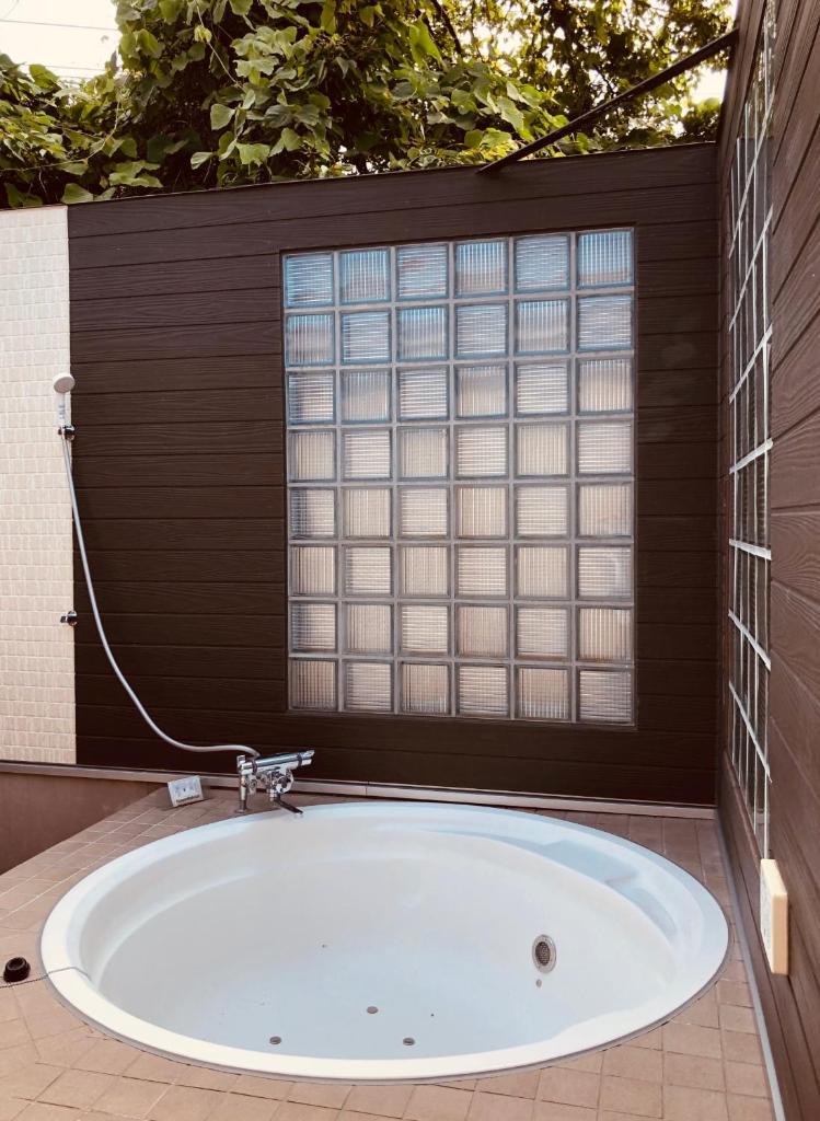 une baignoire dans une salle de bain avec une fenêtre dans l'établissement HOTEL KAZAN (Adult Only), à Iwaki 28 autres photos