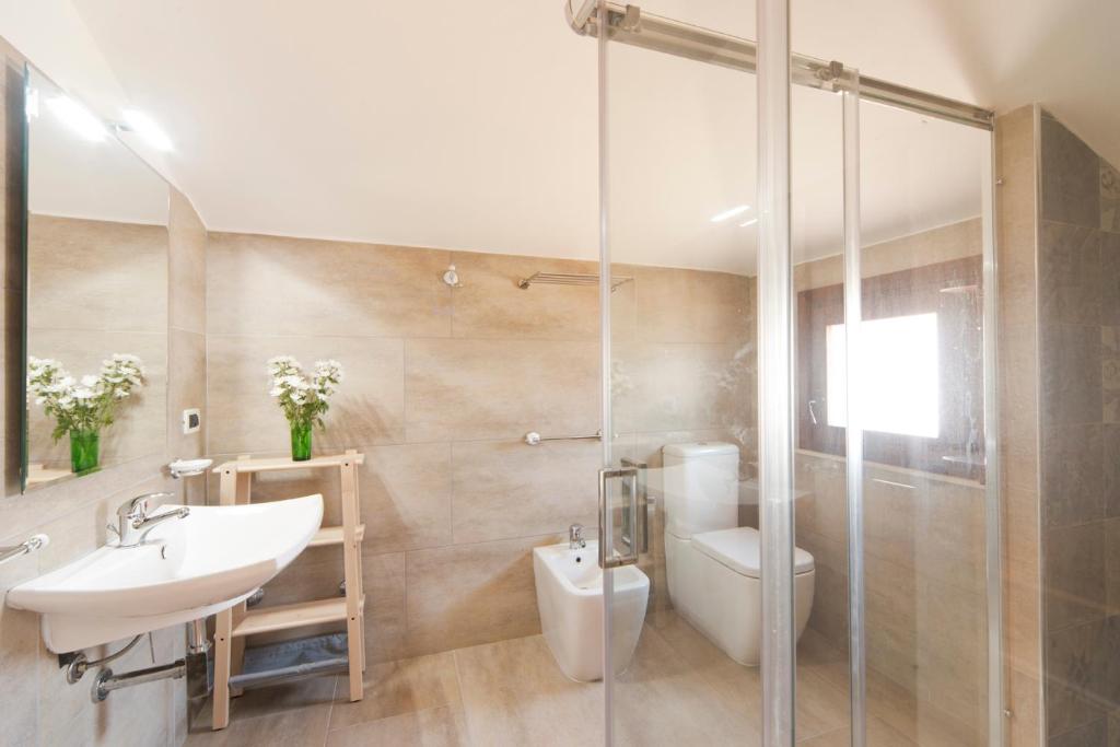 une salle de bain avec un lavabo, des toilettes et une douche dans l'établissement Villa Anbegia, à Syracuse
