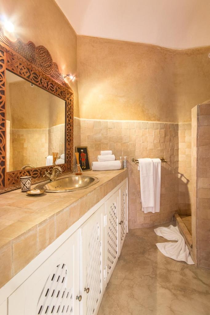 une salle de bain avec un lavabo et un miroir dans l'établissement Riad Helen, à Marrakech
