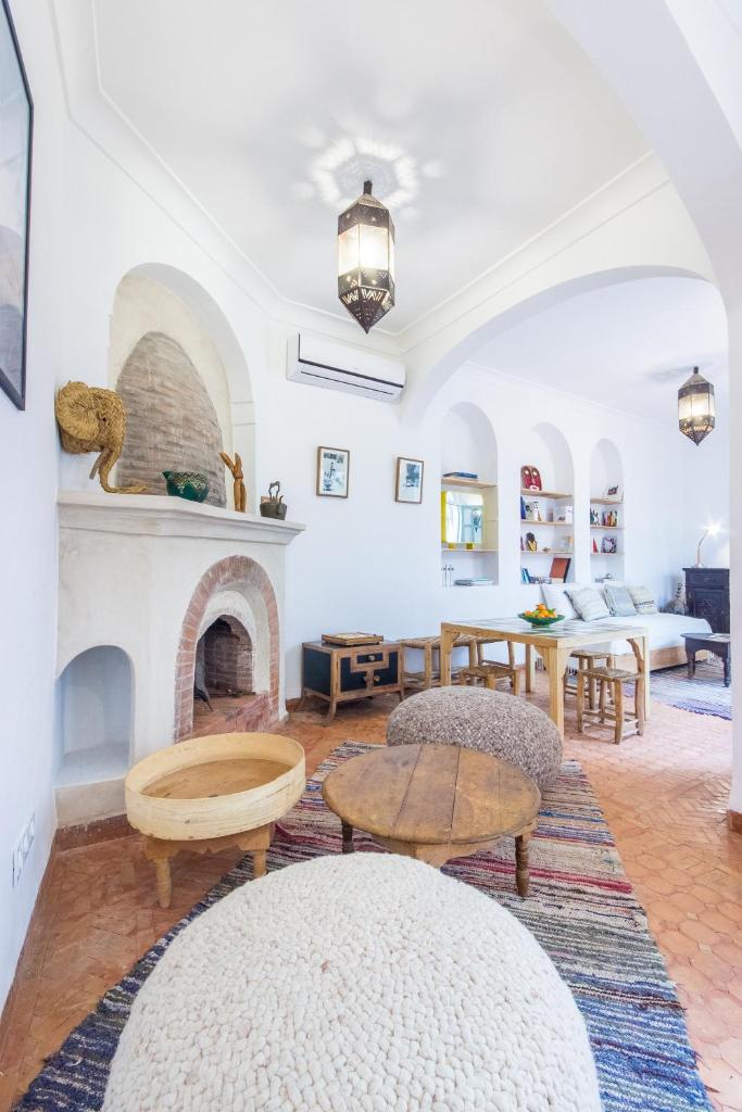 un salon avec une cheminée et une table dans l'établissement Riad Helen, à Marrakech