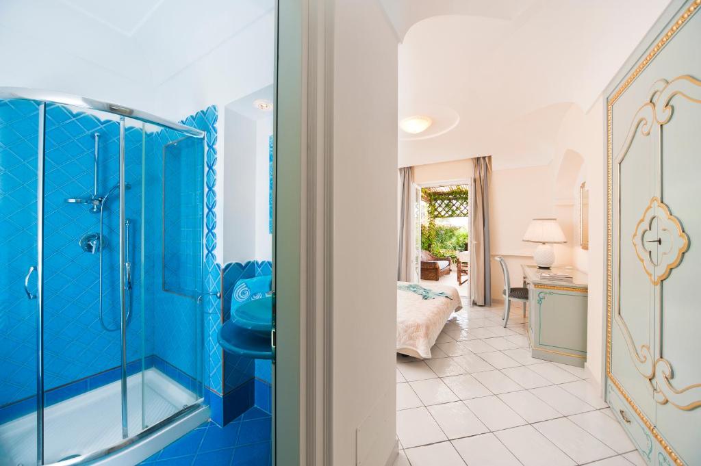 Il comprend une chambre et une salle de bains bleue pourvue d'une douche. dans l'établissement Villa Formica, a due passi dal mare, à Ischia