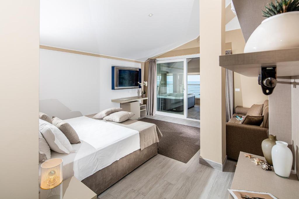 une chambre avec un grand lit et un salon dans l'établissement Hotel Capitol, à Lido di Jesolo 66 autres photos