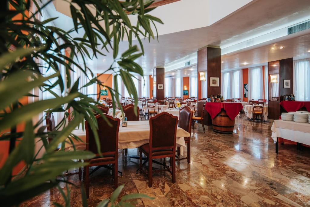 une salle à manger avec une longue table et des chaises dans l'établissement Hotel Capitol, à Lido di Jesolo