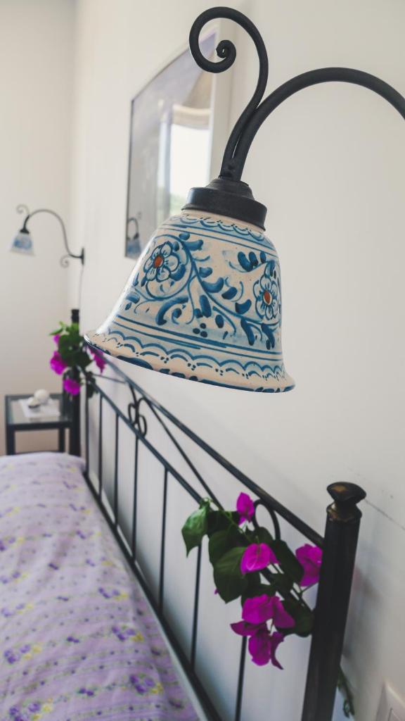 une lampe bleue et blanche suspendue au-dessus d'un lit dans l'établissement Le 7 sorelle, à Lipari