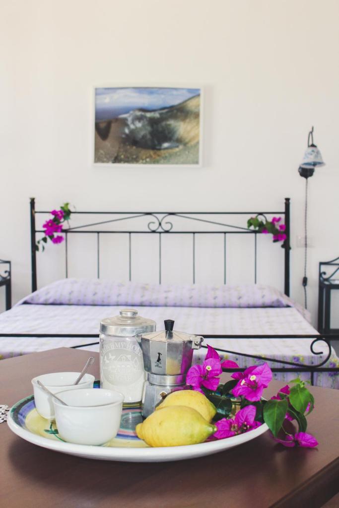 une assiette de nourriture sur une table devant un lit dans l'établissement Le 7 sorelle, à Lipari