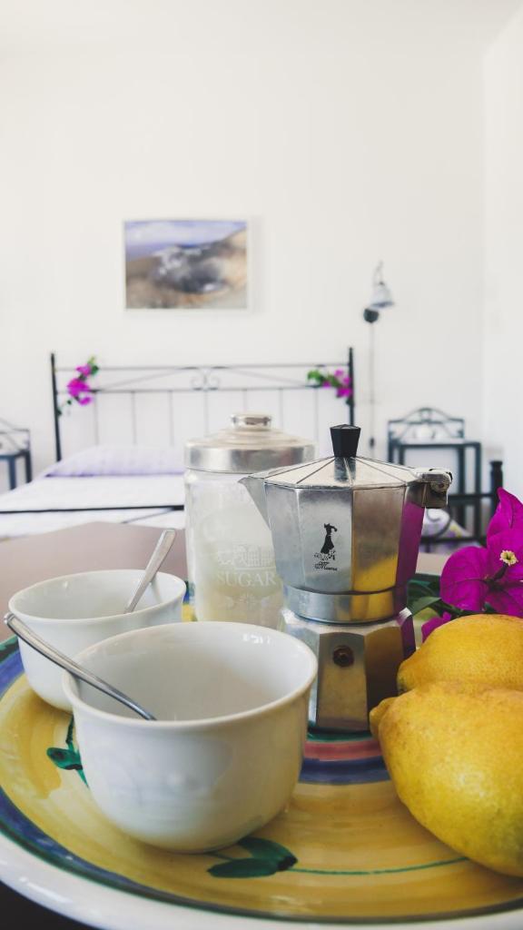 une table avec 2 bols sur une plaque avec presse-agrumes dans l'établissement Le 7 sorelle, à Lipari