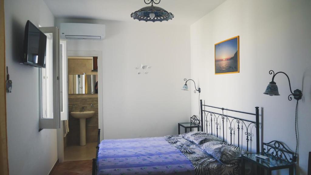 - une chambre avec un lit et un couloir avec un lavabo dans l'établissement Le 7 sorelle, à Lipari