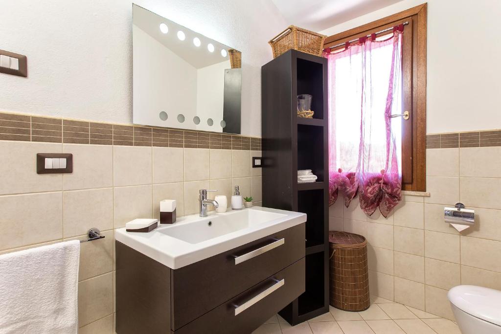 une salle de bain avec un lavabo et un miroir dans l'établissement Villa Pedra Alghero - appartamento in villa con piscina, à Alghero 34 autres photos
