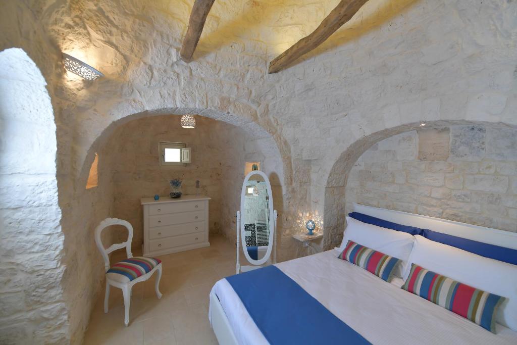une chambre avec un lit et un mur en pierre dans l'établissement Trulli Santa Croce - Luxury Holiday -, à Locorotondo 57 autres photos