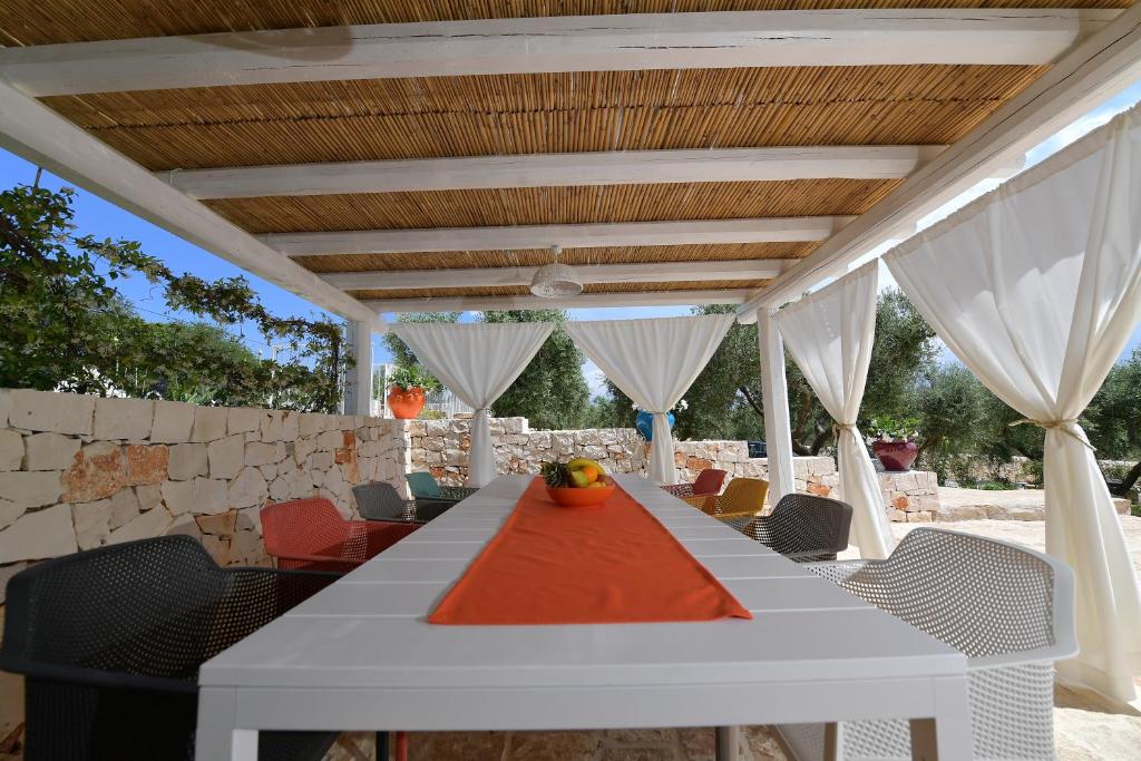une table blanche et des chaises sur une terrasse dans l'établissement Trulli Santa Croce - Luxury Holiday -, à Locorotondo