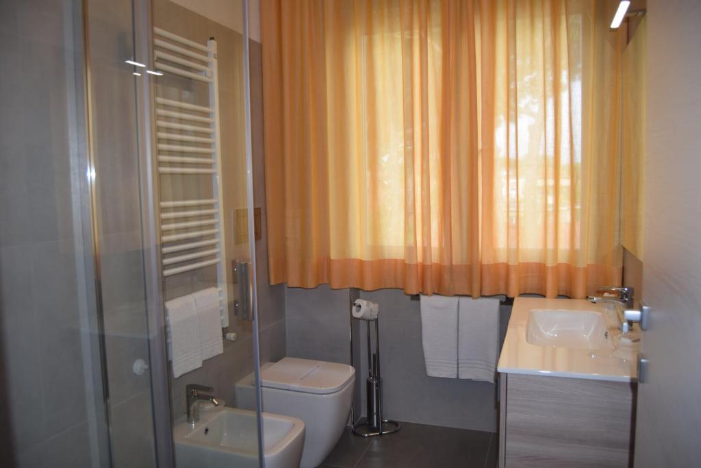 une salle de bain avec toilettes, lavabo et douche dans l'établissement Orchidea Marina, à Tirrenia