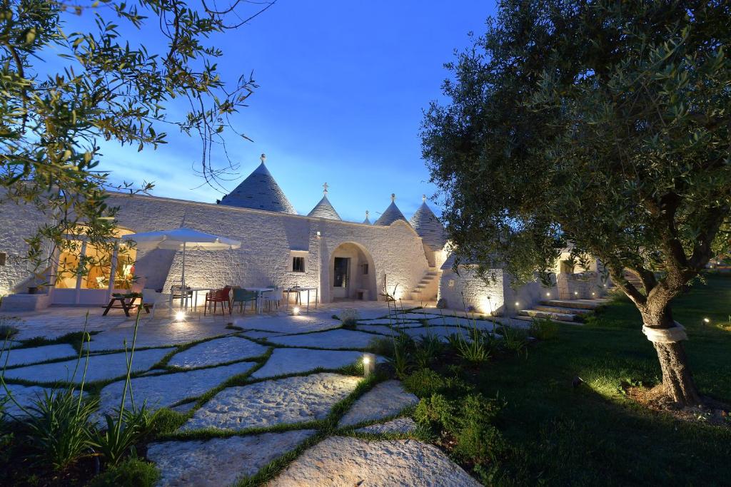 une cour avec un arbre et des lumières dans l'établissement Trulli Santa Croce - Luxury Holiday -, à Locorotondo
