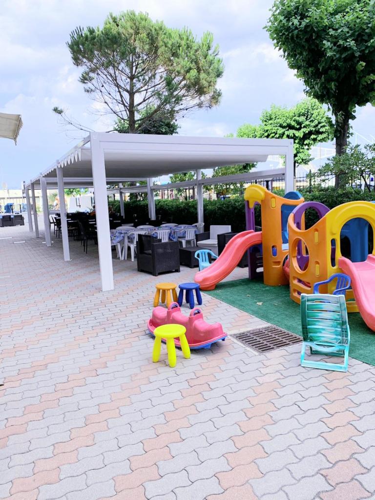 - une aire de jeux avec des équipements de jeux colorés sur une terrasse dans l'établissement Hotel Mercedes, à Misano Adriatico