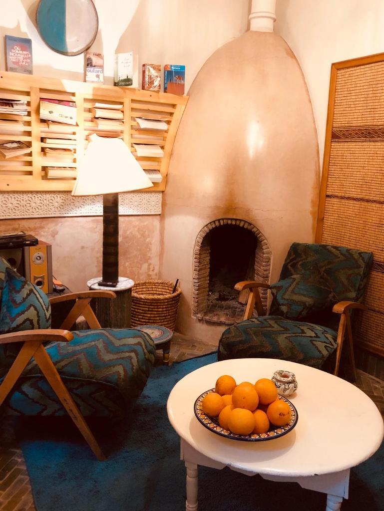 un salon avec une table avec un bol d'oranges dans l'établissement Riad Le Coq Berbère, à Marrakech