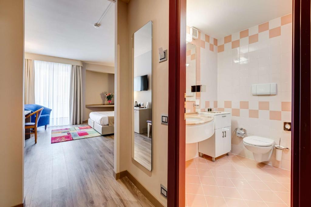 une salle de bain avec un lavabo et des toilettes dans une chambre dans l'établissement Best Western Hotel Imperiale, à Nova Siri Marina