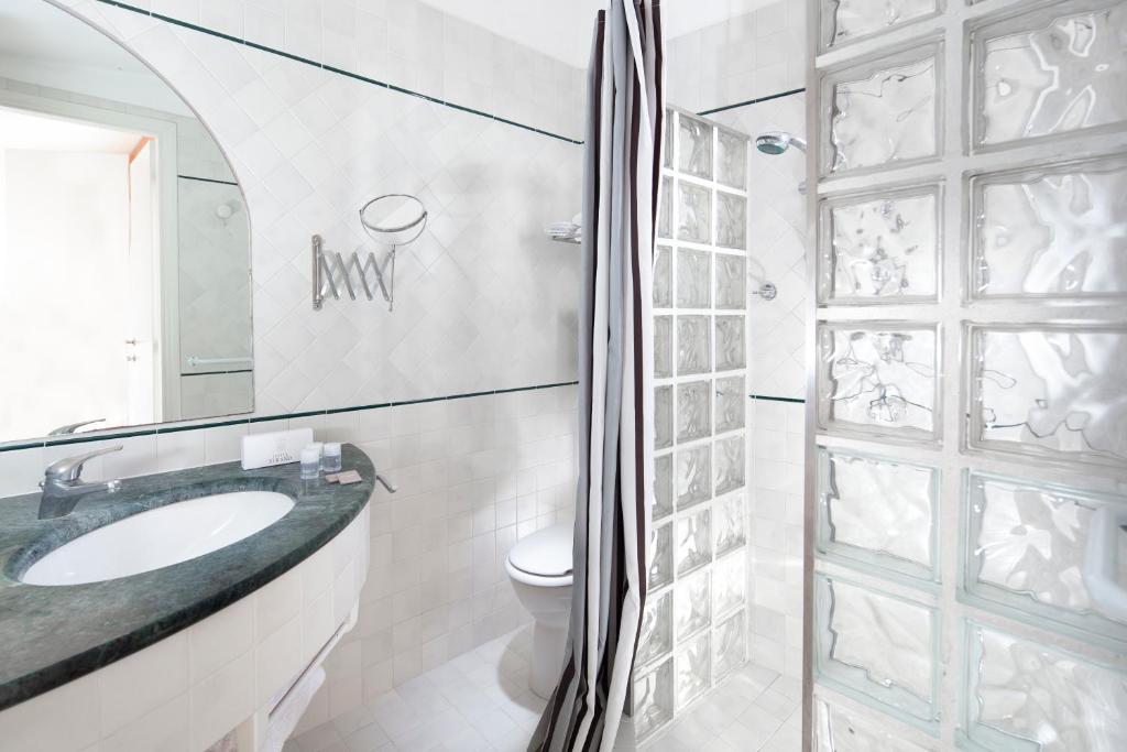 une salle de bain blanche avec un lavabo et des toilettes dans l'établissement Hotel Strand, à Bellaria-Igea Marina 40 autres photos