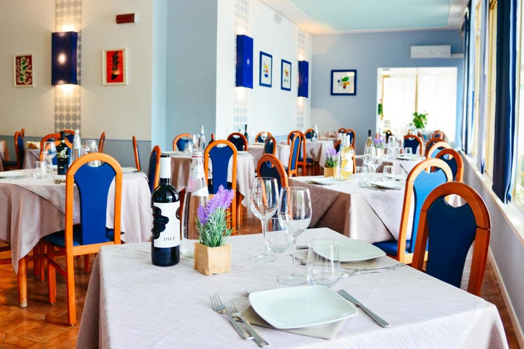 un restaurant avec tables et chaises et nappes blanches dans l'établissement Hotel Domingo, à Lido di Jesolo