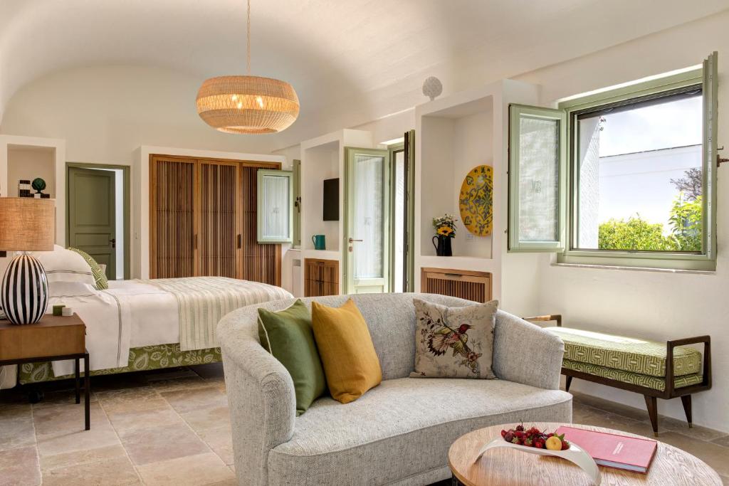 un salon avec un canapé et un lit dans l'établissement Rocco Forte Masseria Torre Maizza, à Savelletri di Fasano