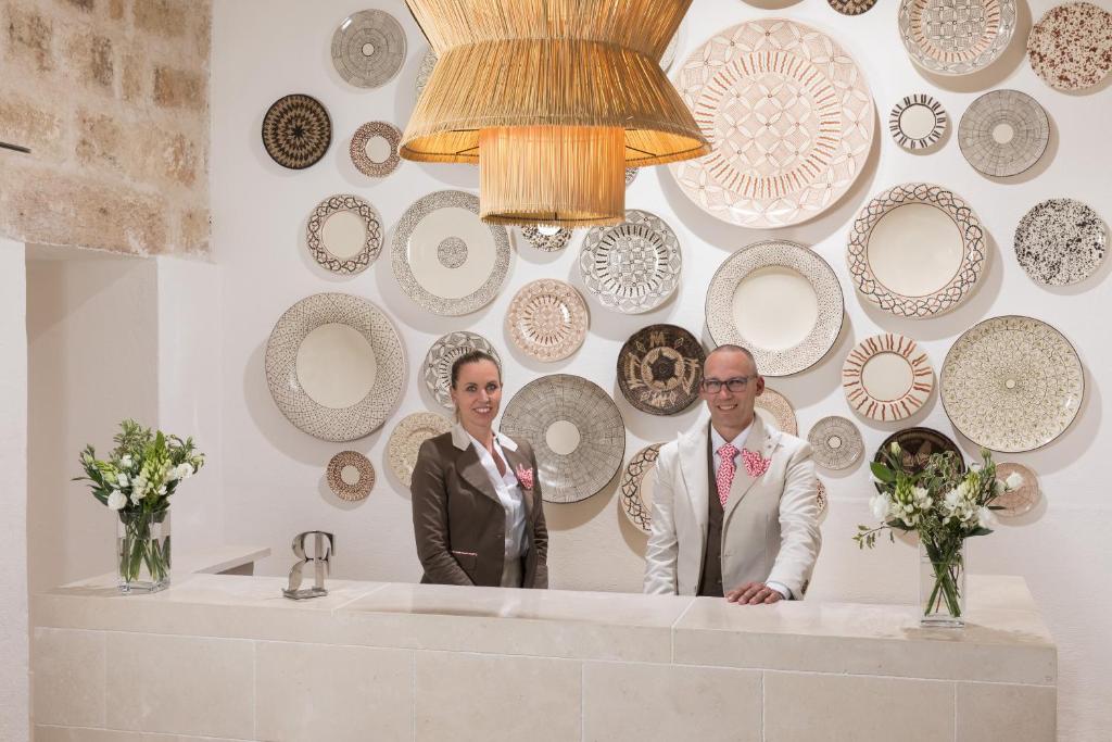 deux personnes debout derrière un comptoir avec des plaques sur le mur dans l'établissement Rocco Forte Masseria Torre Maizza, à Savelletri di Fasano 58 autres photos