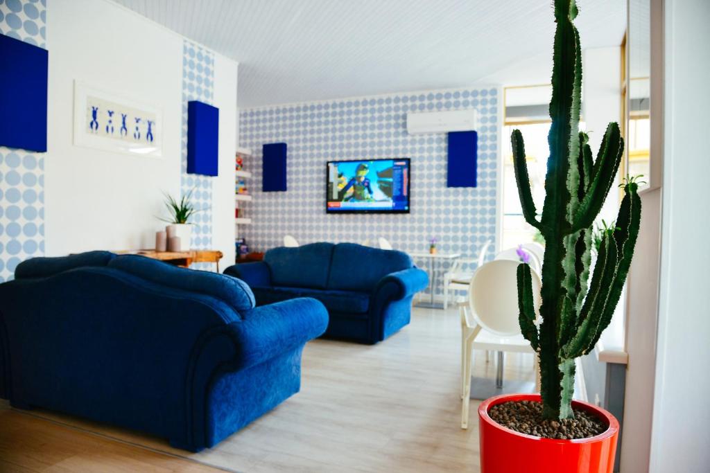 - un salon avec deux canapés bleus et un cactus dans l'établissement Hotel Domingo, à Lido di Jesolo