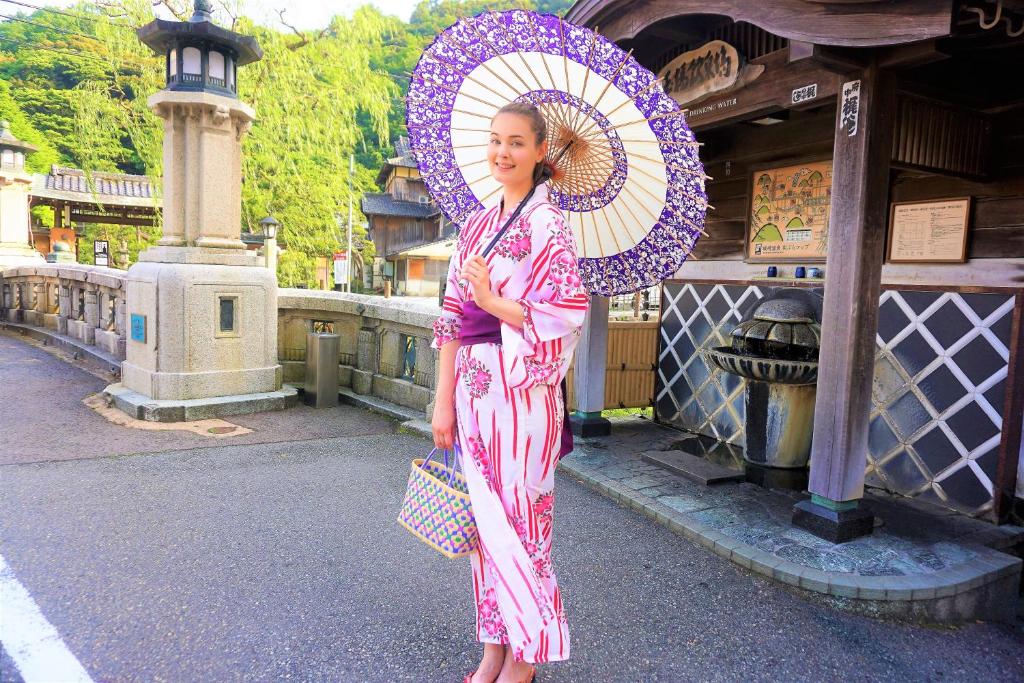 une femme en robe rose tenant un parapluie dans l'établissement Morizuya, à Toyooka 37 autres photos
