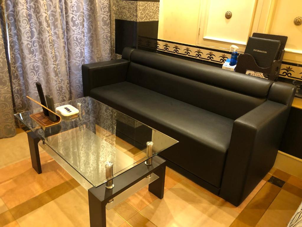 un banc dans un salon avec une table en verre dans l'établissement Restay Puchi Nagasaki Club (Adult Only), à Nagasaki