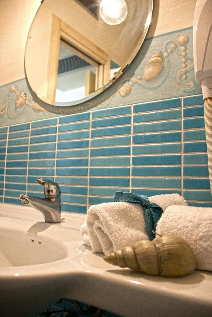 une salle de bain avec un lavabo et un miroir dans l'établissement Villa Mazzanta Relais & Hotel, à Vada 59 autres photos