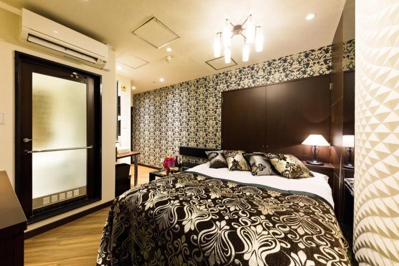 une chambre avec un grand lit dans une pièce dans l'établissement HOTEL VERSYS (Adult Only), à Hiroshima