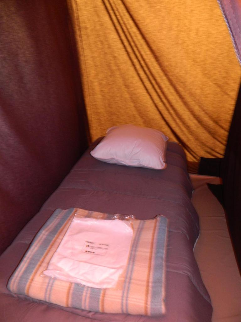 - un petit lit avec un oreiller et une serviette dans l'établissement Oh! Campings La Brise, à Saintes-Maries-de-la-Mer 33 autres photos