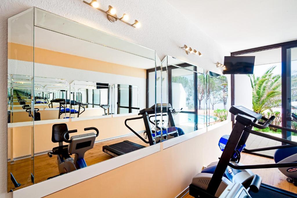 - une salle de sport avec tapis de course et vélos elliptiques dans une maison dans l'établissement Grand Hotel Pianeta Maratea Resort, à Maratea
