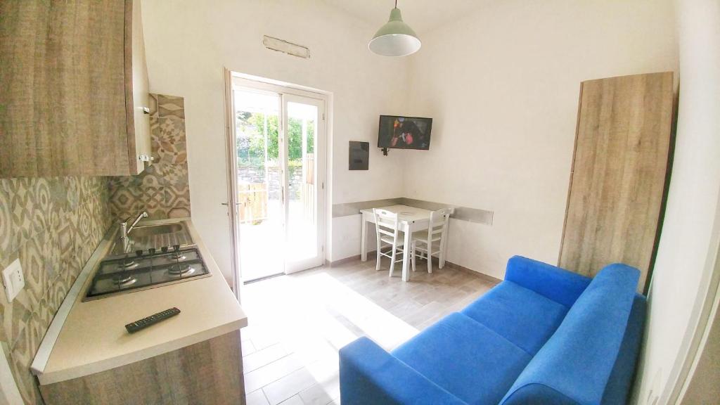 un salon avec un canapé bleu et une cuisine dans l'établissement Tenuta Marga, à Agnone
