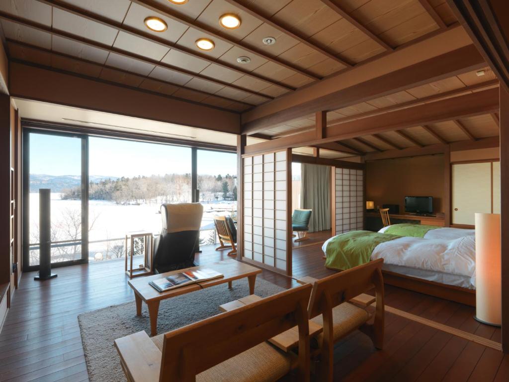 une chambre avec un lit et une grande fenêtre dans l'établissement Akan Tsuruga Besso Hinanoza, à Akankohan