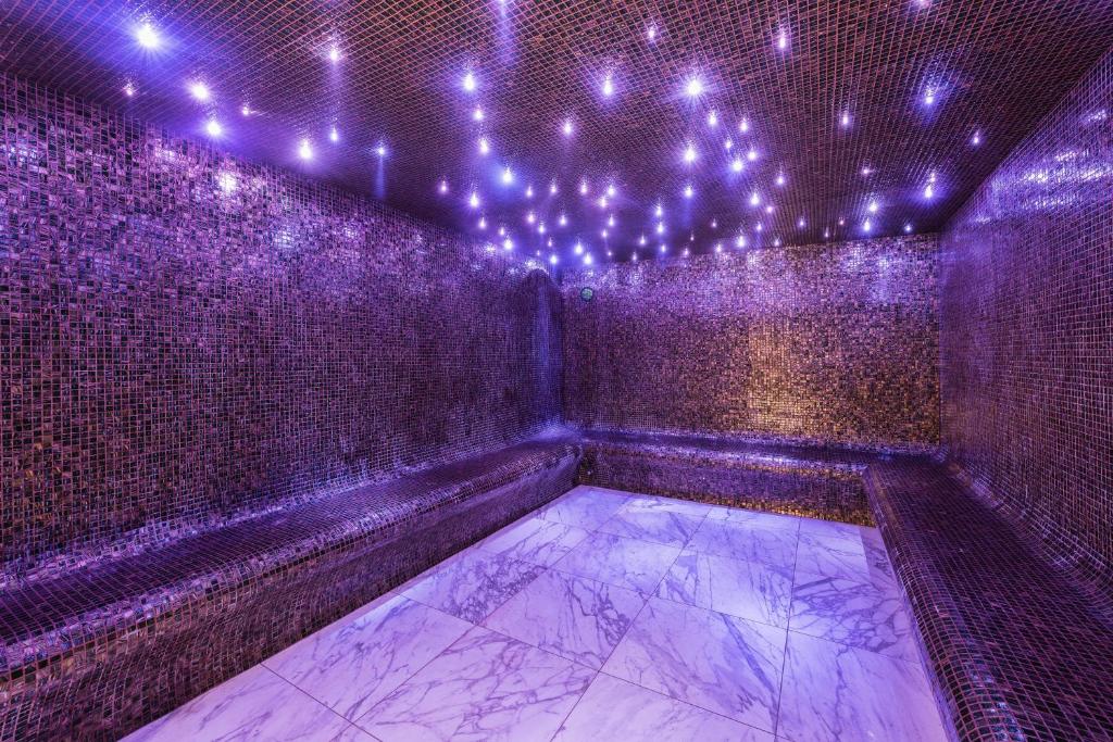 une pièce vide avec des lumières violettes sur un mur dans l'établissement Fahrenheit Seven Courchevel, à Courchevel