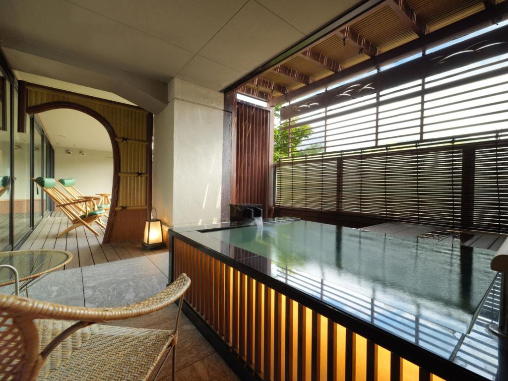 d'un balcon avec une table et des chaises en verre. dans l'établissement Akan Tsuruga Besso Hinanoza, à Akankohan 37 autres photos