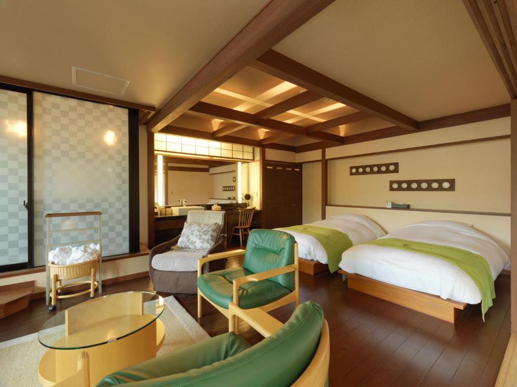 une chambre avec deux lits et un salon dans l'établissement Akan Tsuruga Besso Hinanoza, à Akankohan