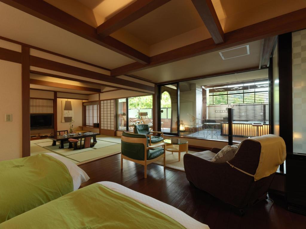 une chambre avec deux lits et un salon dans l'établissement Akan Tsuruga Besso Hinanoza, à Akankohan