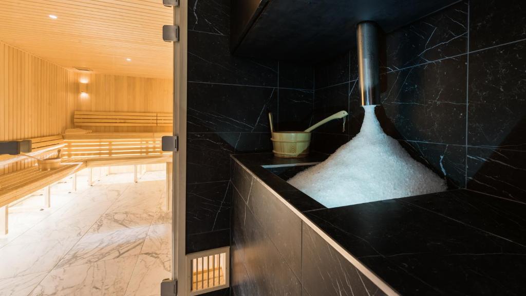 La salle de bains est pourvue d'un lavabo noir et d'une baignoire. dans l'établissement Fahrenheit Seven Courchevel, à Courchevel